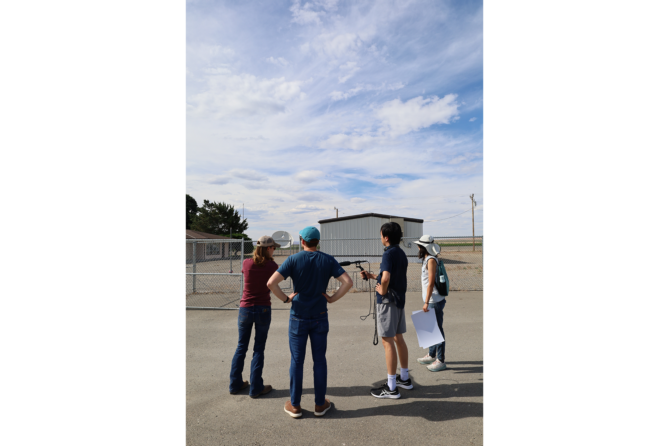 Nate, Susan, Chris, and Jessica look at the existing Orovada schoolhouse. The two-lane asphalt road behind it leads to the mine. Photo by Jose Santacruz.