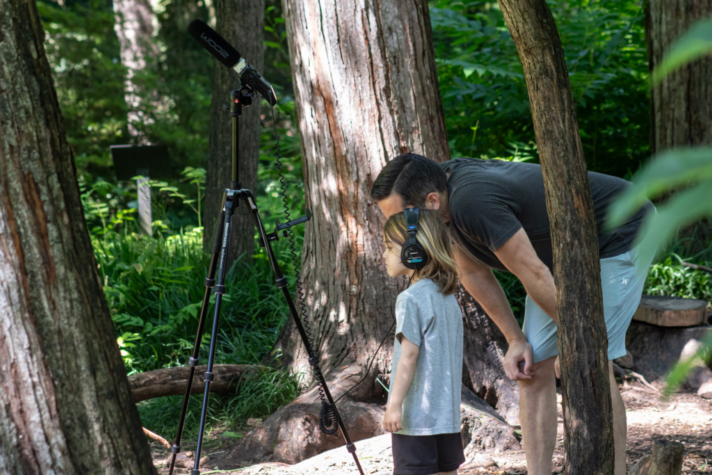 A father and daughter listen to forest sounds at the "Tune into the forest" station.