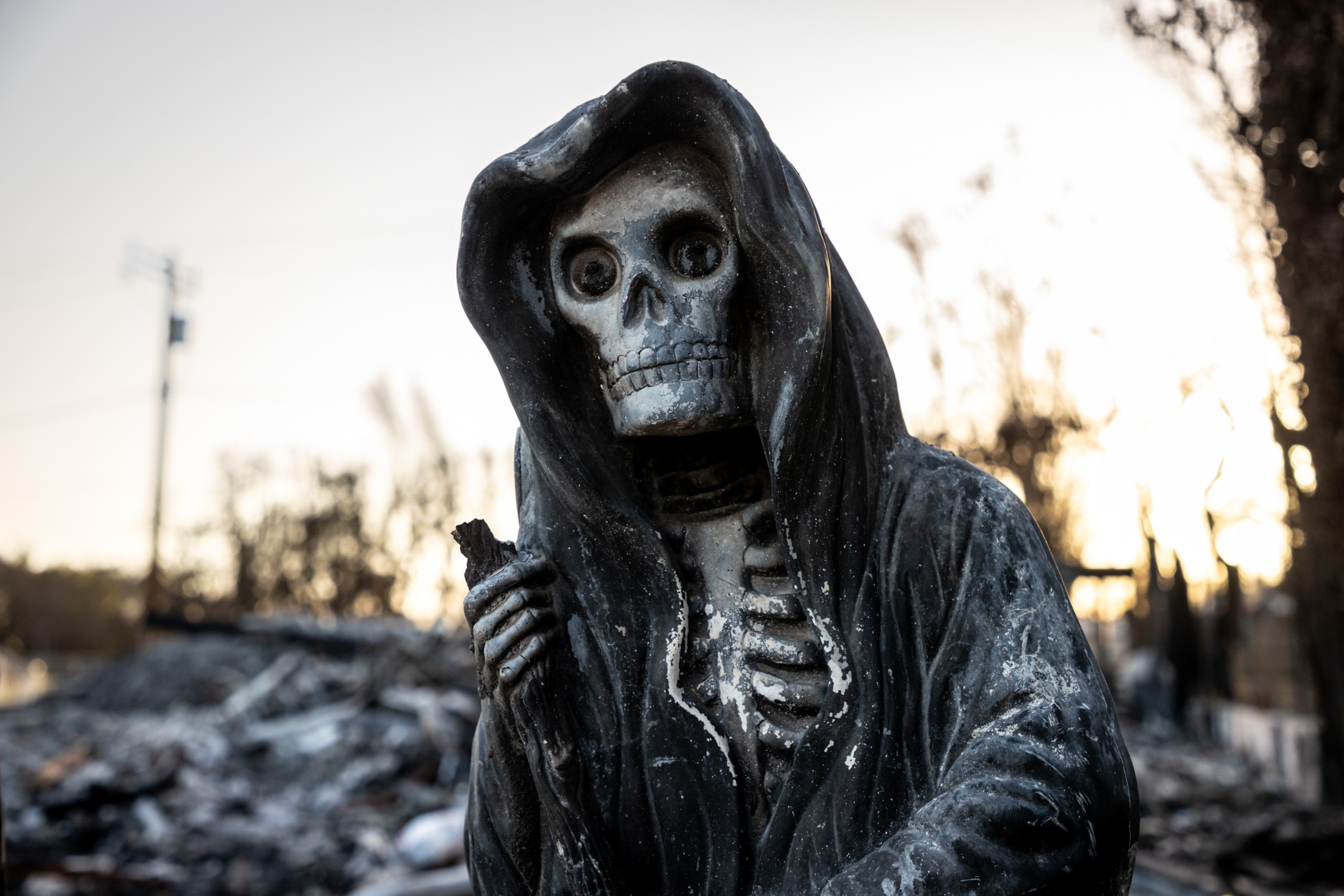A skeleton statue amid the rubble of the Palisades Fire