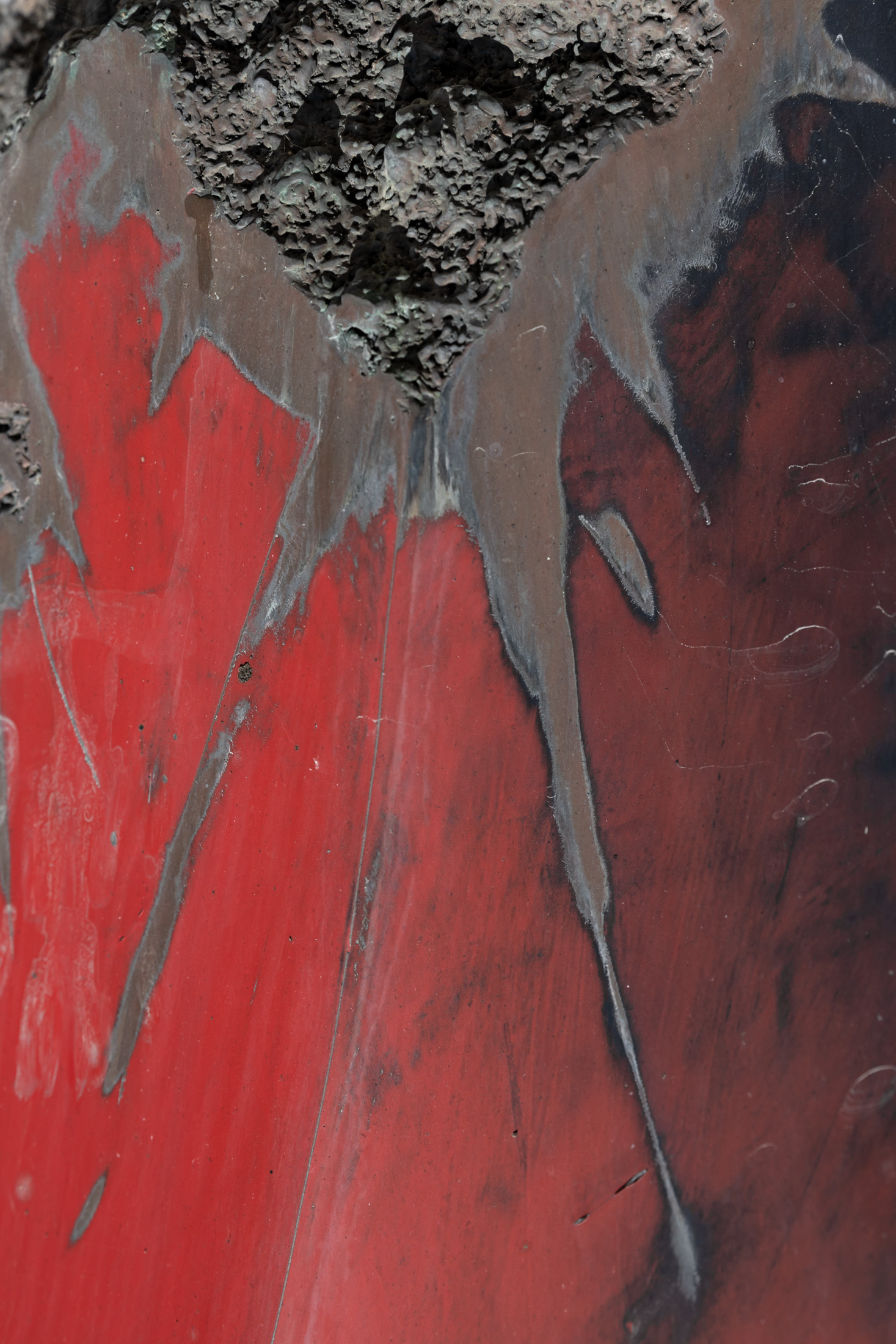 A fire-damaged red garden sculpture, abstract